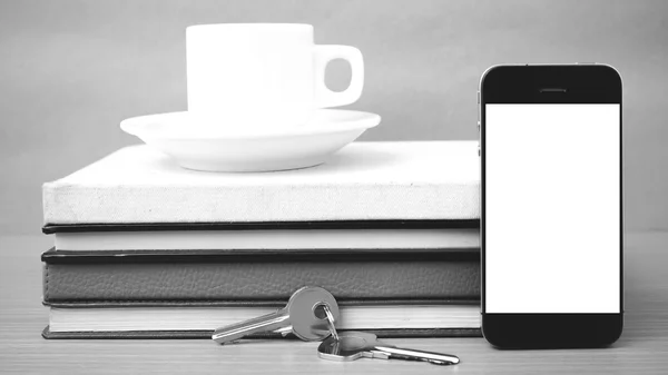 coffee cup with phone key and stack of book