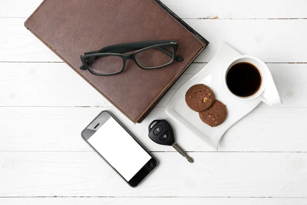 Чашка кави з печивом, телефоном, стосом книги та ключем автомобіля — стокове фото