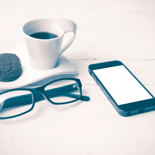 Xícara de café com biscoito, telefone e óculos estilo vintage — Fotografia de Stock