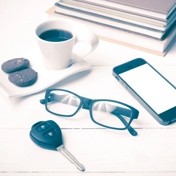 Kávé csésze a cookie-k, telefon, autó kulcs, szemüvegek, halom könyv — Stock Fotó