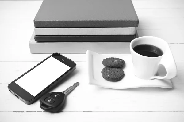 Taza de café con galletas, teléfono, llave del coche y pila de libro negro y — Foto de Stock