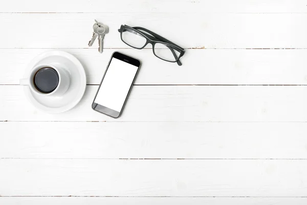 Чашка кави з телефоном, окулярами та ключем — стокове фото