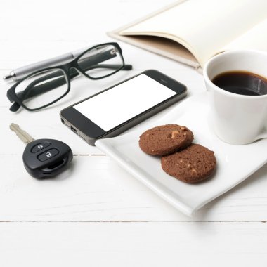 kahve fincanı ile tanımlama bilgisi, telefon, açık defter, araba anahtarı ve eyeglasse