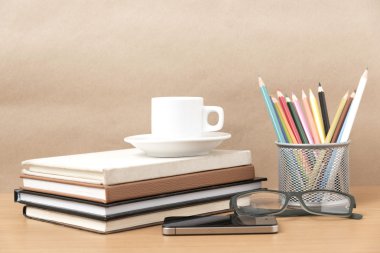 kahve, telefon, gözlük, kitap ve renk kalem yığını