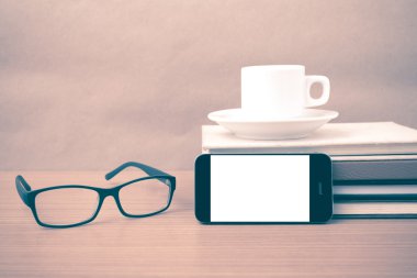 kahve, telefon, kitap ve gözlük yığını