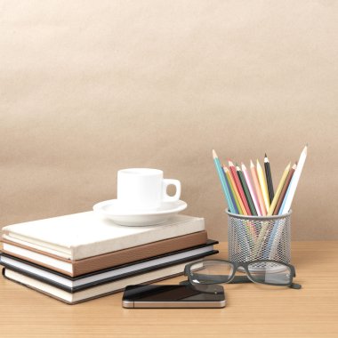 kahve, telefon, gözlük, kitap ve renk kalem yığını
