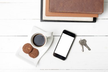 tanımlama bilgisi, telefon, kitap ve anahtar yığını ile kahve fincanı