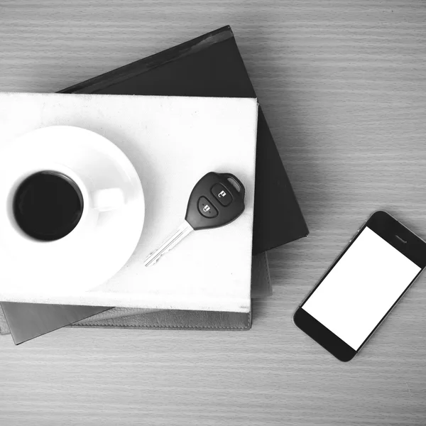 Чашка кави з ключем телефону автомобіля і стопка книги — стокове фото