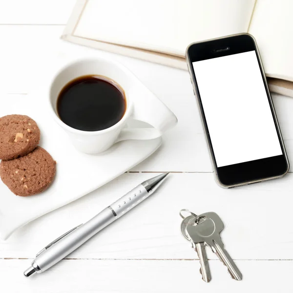 Xícara de café com biscoito, telefone, caderno e chave — Fotografia de Stock