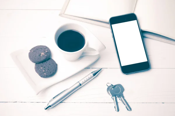 Xícara de café com biscoito, telefone, caderno e chave estilo vintage — Fotografia de Stock