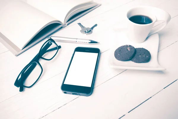 Xícara de café com biscoito, telefone, caderno aberto, chave e óculos vi — Fotografia de Stock