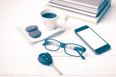 Kahve Kupası ile tanımlama bilgisi, telefon, araba anahtarı, gözlük ve kitap yığını
