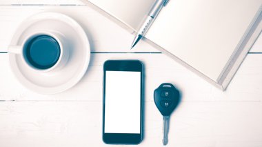 kahve fincanı ile telefon, araba anahtarı ve açık defter vintage tarzı