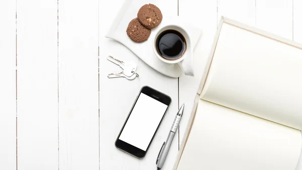 coffee cup with cookie,phone,notebook and key