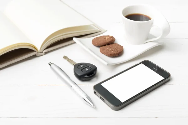 Чашка кави з печивом, телефоном, відкритим записником та ключем автомобіля — стокове фото