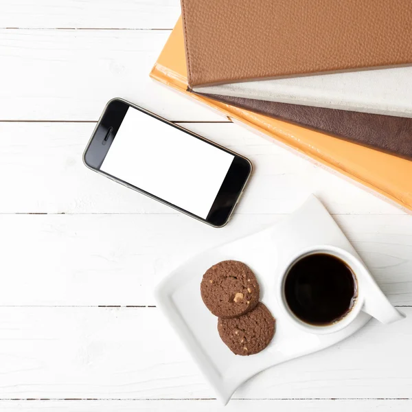 Xícara de café com biscoito, telefone e pilha de livro — Fotografia de Stock