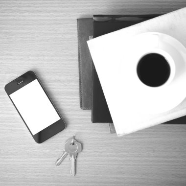 kahve fincanı ile telefon anahtar ve kitap yığını