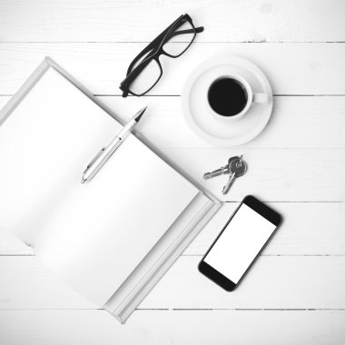 kahve fincanı ile telefon, anahtar, gözlük ve açık defter siyah bir