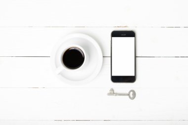 kahve fincanı ile telefon ve anahtar