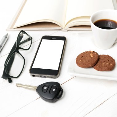 kahve fincanı ile tanımlama bilgisi, telefon, açık defter, araba anahtarı ve eyeglasse