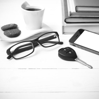 Kahve Kupası ile tanımlama bilgisi, telefon, araba anahtarı, gözlük ve kitap yığını