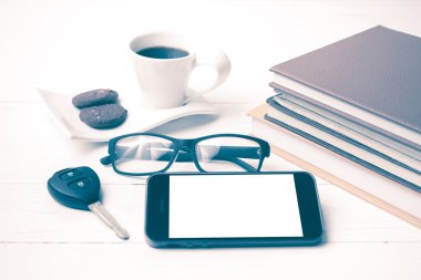 Kahve Kupası ile tanımlama bilgisi, telefon, araba anahtarı, gözlük ve kitap yığını