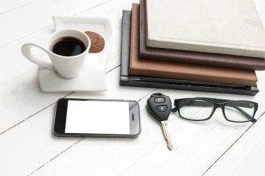 tanımlama bilgisi, telefon, kitap ve araba anahtar yığını ile kahve fincanı 