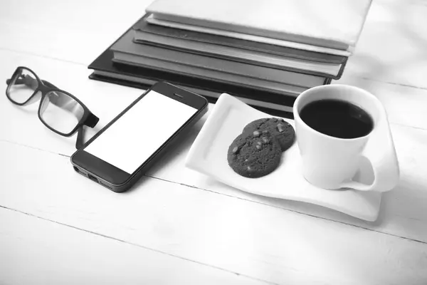 Taza de café con galletas, teléfono, pila de libros y anteojos negro — Foto de Stock