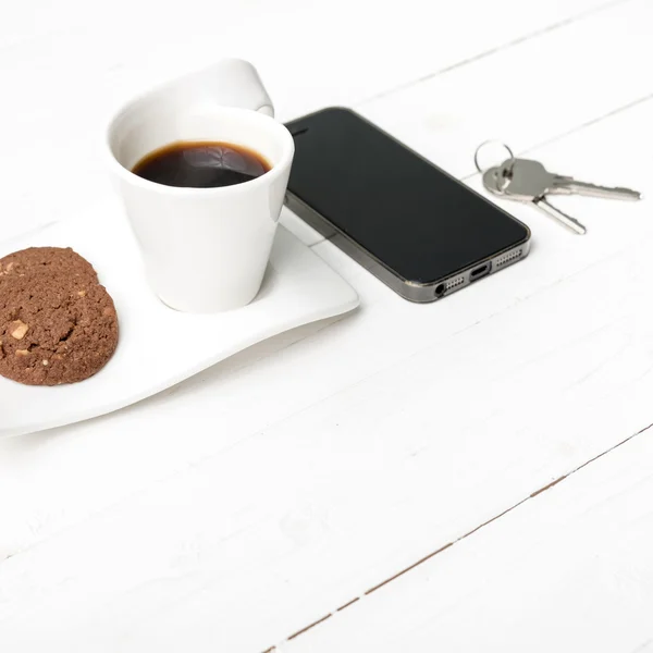 Taza de café con galletas, teléfono y llave — Foto de Stock