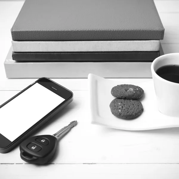 Чашка кави з печивом, телефоном, ключем автомобіля і стосом книги чорний і — стокове фото