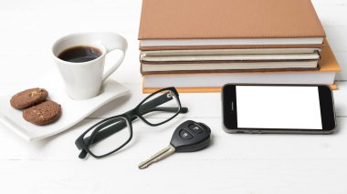 Kahve Kupası ile tanımlama bilgisi, telefon, araba anahtarı, gözlük ve kitap yığını