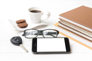 Kahve Kupası ile tanımlama bilgisi, telefon, araba anahtarı, gözlük ve kitap yığını