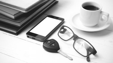 kahve fincanı ile telefon, araba anahtarı, gözlük ve kitap blac yığını
