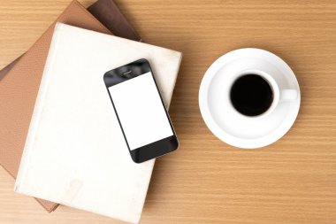 kahve fincanı ve telefon ve kitap yığını