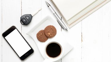 tanımlama bilgisi, telefon, açık defter ve araba anahtarı ile kahve fincanı