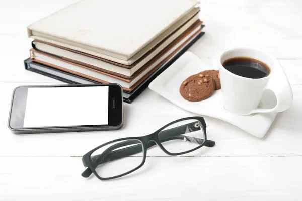 Taza de café con galletas, teléfono, pila de libros y anteojos — Foto de Stock