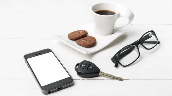 Taza de café con galletas, teléfono, anteojos y llave del coche —  Fotos de Stock