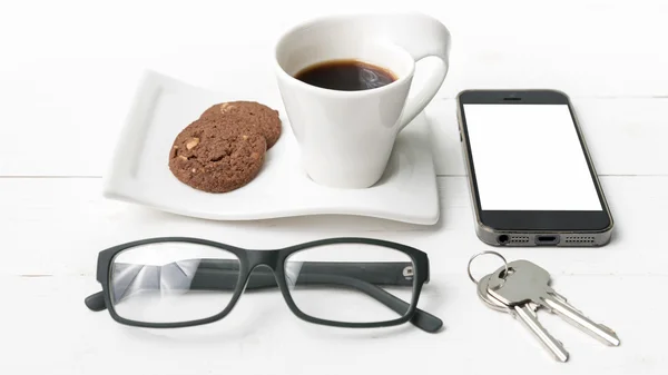 Кофейная чашка с печеньем, телефон, очки и ключ — стоковое фото