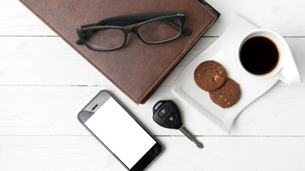 Чашка кави з печивом, телефоном, стосом книги та ключем автомобіля — стокове фото