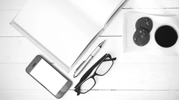 Xícara de café com biscoito, telefone, caderno e óculos pretos e w — Fotografia de Stock