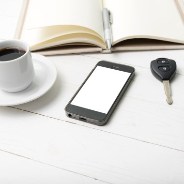 kahve fincanı ile telefon, araba anahtarı ve açık defter