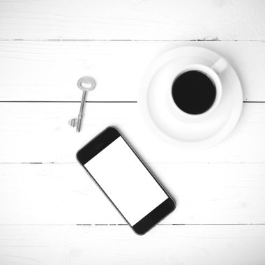 kahve fincanı ile telefon ve anahtar siyah ve beyaz renk