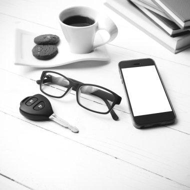 Kahve Kupası ile tanımlama bilgisi, telefon, araba anahtarı, gözlük ve kitap yığını