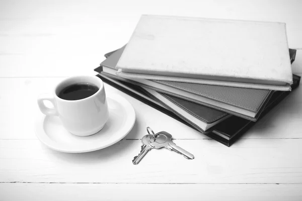 Tazza di caffè, chiave e pila di libro colore bianco e nero — Foto Stock