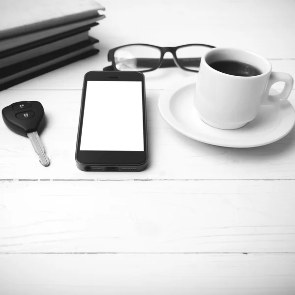 Taza de café con teléfono, llave del coche, anteojos y pila de blac libro —  Fotos de Stock