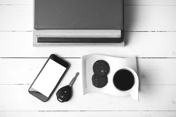 Taza de café con galletas, teléfono, llave del coche y pila de libro negro y — Foto de Stock
