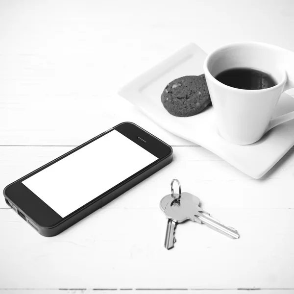 Kaffeetasse mit Plätzchen, Telefon und Schlüssel schwarz-weiß — Stockfoto