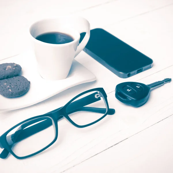 Šálek kávy s cookie, telefon, brýle a auto klíče vintage styl — Stock fotografie