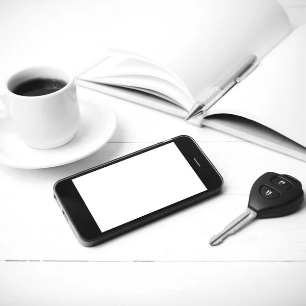 Csésze kávé a phone, a autó kulcs és a nyílt notebook fekete-fehér — Stock Fotó