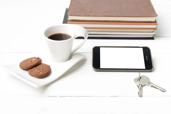 Koffiekopje met cookie, telefoon, stack van boek en sleutel — Stockfoto